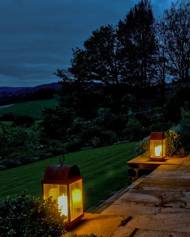 Two lanterns frame the stone steps down to the garden in a beautiful setting