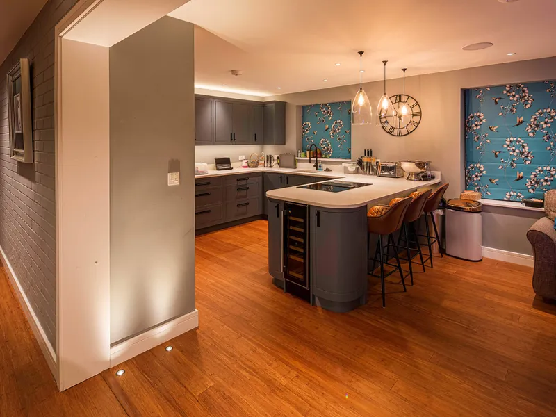 A kitchen and breakfast bar with pendant lighting over the island