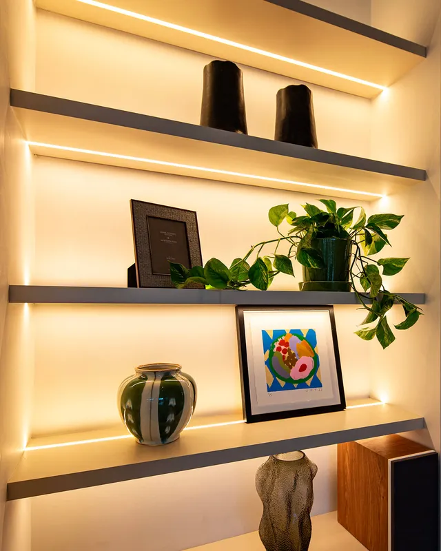 Detail of recessed LED linear lighting in the topside and underside of built-in shelving