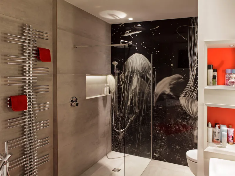 Bright bathroom lighting with lit niches and a shower with sealife artwork