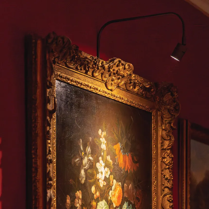 Large framed painting evenly illuminated with specialist fine art lighting in a private home
