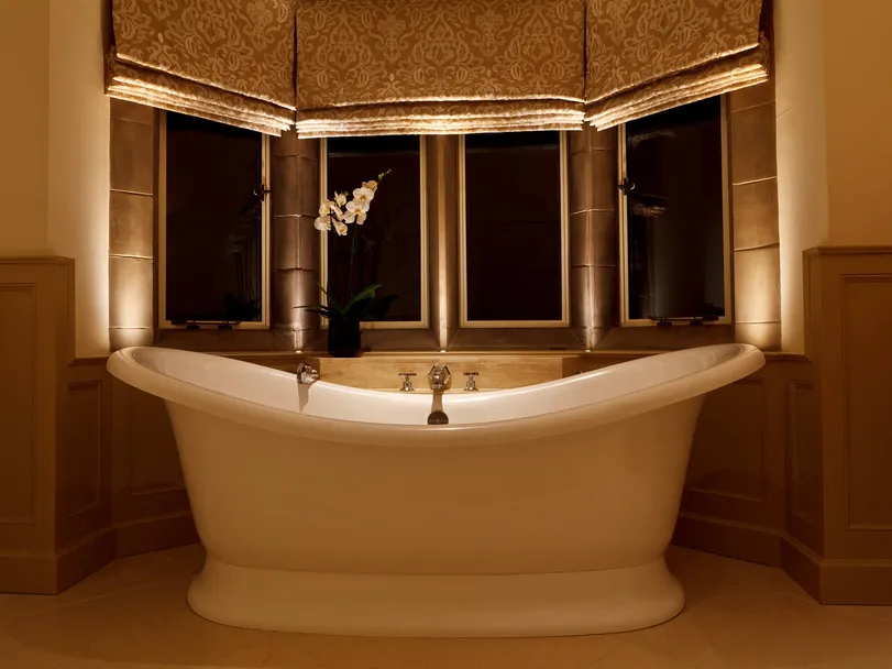 A roll top bath in an Arts & Crafts bathroom subtly lit with downlights and cill recessed accent lights