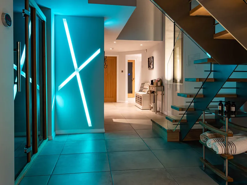 Colour changing recessed linear LED lighting in a new-build house, cyan