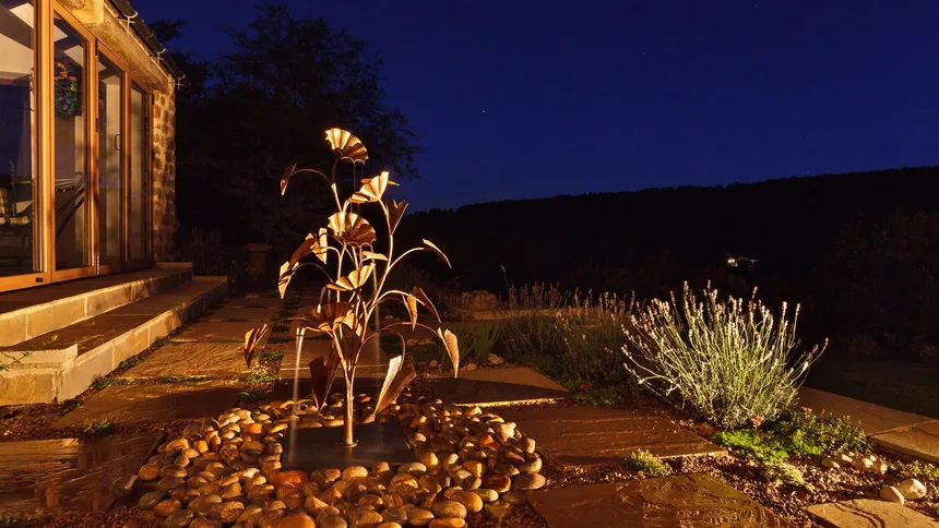 Copper water feature lit with discreet wall mounted accent light in a Yorkshire garden