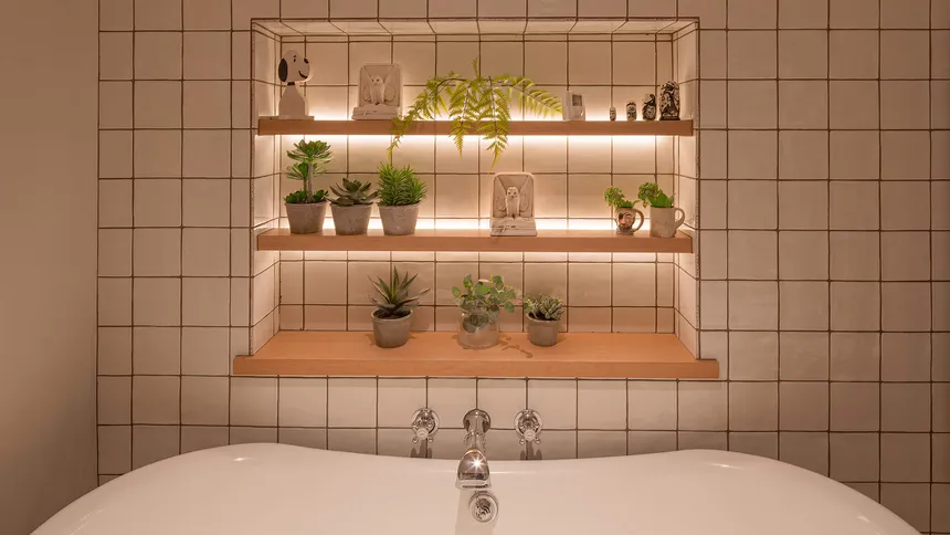 Shelves lit with linear LED in an elegant bathroom with roll top bath