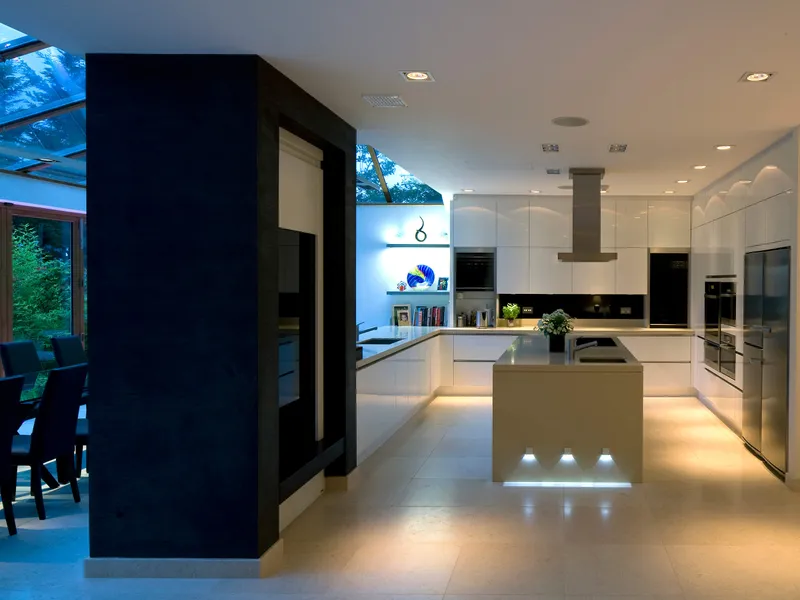 An open plan kitchen and dining room  separated by a large fireplace